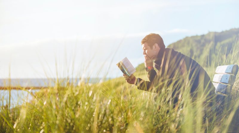 man reading book outdoors